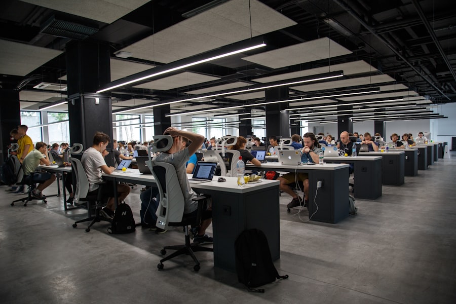 People working around laptops in a dim room.